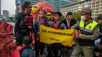 Petugas Satpol PP membubarkan aksi aktivis Greenpeace Indonesia saat menggelar kampanye tanpa oligarki di Bundaran Hotel Indonesia (HI), Jakarta, Jumat (6/10/2023). [ANTARA FOTO/Muhammad Adimaja/nym]