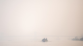 Perahu tradisional melewati sungai musi yang tertutup kabut asap di Palembang, Sumatera Selatam, Sabtu (7/10/2023). [ANTARA FOTO/Nova Wahyudi/YU]