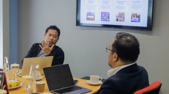 Pemimpin Redaksi Suara.com, Suwarjono (kiri) memberikan pemaparan saat menerima kunjungan dari rekan-rekan mitra media regional International Media Supports (IMS) di Kantor Suara.com, Jakarta, Selasa (10/10/2023). [Suara.com/Alfian Winanto]
