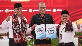 Bakal calon Presiden Anies Baswedan (kiri) bersama bakal calon Wakil Presiden Muhaimin Iskandar (kanan) dan Ketua KPU Hasyim Asy'ari (tengah) saat melakukan pendaftaran Calon Presiden dan Wakil Presiden Pemilihan Umum 2024 di Gedung KPU, Jakarta, Kamis (19/10/2023). [Suara.com/Alfian Winanto]