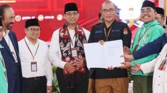 Bakal calon Presiden Anies Baswedan (tengah) bersama bakal calon Wakil Presiden Muhaimin Iskandar (kiri) dan Ketua KPU Hasyim Asy'ari (kanan) saat melakukan pendaftaran Calon Presiden dan Wakil Presiden Pemilihan Umum 2024 di Gedung KPU, Jakarta, Kamis (19/10/2023). [Suara.com/Alfian Winanto]