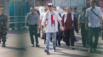 Mantan juru bicara Front Pembela Islam (FPI) Munarman (tengah) berjalan keluar usai bebas dari penjara di Rutan Salemba, Jakarta, Senin (30/10/2023). [Suara.com/Alfian Winanto]