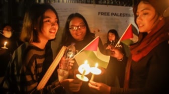 Sejumlah elemen masyarakat menyalakan lilin saat mengikuti aksi damai Bela Palestina di Kedutaan Besar Palestina, Jakarta, Kamis (2/11/2023). [Suara.com/Alfian Winanto]