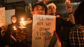 Sejumlah elemen masyarakat menyalakan lilin saat mengikuti aksi damai Bela Palestina di Kedutaan Besar Palestina, Jakarta, Kamis (2/11/2023). [Suara.com/Alfian Winanto]