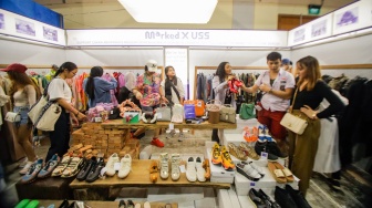 Pengunjung memilih barang dalam acara Urban Sneaker Society (USS) 2023 yang diselenggarakan di JCC Senayan, Jakarta, Minggu (5/11/2023). [Suara.com/Alfian Winanto]