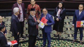 Ketua Majelis Kehormatan Mahkamah Konstitusi (MKMK) Jimly Asshiddiqie memberikan salinan putusan kepada para pelapor usai sidang putusan etik di Gedung MK, Jakarta, Selasa (7/11/2023). [Suara.com/Alfian Winanto]