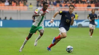 Pesepak bola Timnas Burkina Faso U-17 Alio Souleymane menggiring bola melewati pemain Timnas Prancis U-17 Sadi Aymen pada pertandingan Grup E Piala Dunia U-17 2023 di Jakarta International Stadium (JIS), Jakarta, Minggu (12/11/2023). [Suara.com/Alfian Winanto]