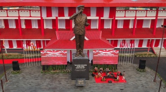 Sejumlah warga berfoto dengan latar belakang Monumen Hoegeng usai diresmikan Kapolri Jenderal Pol Listyo Sigit Prabowo di Kawasan Stadion Hoegeng, Pekalongan, Jawa Tengah, Sabtu (11/11/2023). [ANTARA FOTO/Harviyan Perdana Putra/nz 