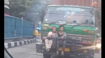 Viral Sejoli Duduk Berduaan di Bumper Depan Truk Kontainer, Warganet: Dunia Milik Berdua