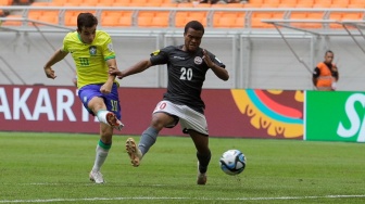 Pesepak bola Timnas Brasil U-17 Dudu menendang bola melewati pemain Timnas Kaledonia Baru U-17 Qaeze Paul pada pertandingan Grup C Piala Dunia U-17 2023 di Jakarta International Stadium (JIS), Jakarta, Selasa (14/11/2023). [Suara.com/Alfian Winanto]