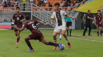 Pesepak bola Timnas Jerman U-17 Noah Darvich berusaha melewati hadangan pemain Timnas Venezuela U-17 Rai Hidalgo pada pertandingan Grup F Piala Dunia U-17 2023 di Jakarta International Stadium (JIS), Jakarta, Sabtu (18/11/2023). [Suara.com/Alfian Winanto]