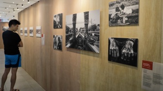 Pengunjung melihat karya yang dipamerkan di Pameran Foto Rekam Jakarta 2023 Masa ke Massa di Galeri Emiria Soenassa, Taman Ismail Marzuki (TIM), Jakarta, Selasa (21/11/2023). [Suara.com/Alfian Winanto]