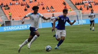 Pesepak bola Timnas Inggris U-17 Josh-kofi Acheampong  berebut bola dengan pemain Timnas Uzbekistan U-17 Bekhruz Shukurullaev pada pertandingan babak 16 besar Piala Dunia U-17 2023 di Jakarta International Stadium (JIS), Jakarta, Rabu (22/11/2023). [Suara.com/Alfian Winanto]