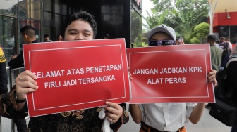 Sejumlah aktivis membawa poster saat menggelar aksi terkait penetapan tersangka Ketua KPK Firli Bahuri di Gedung Merah Putih KPK, Jakarta, Kamis (23/11/2023). [Suara.com/Alfian Winanto]