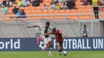 Pesepak bola Timnas Spanyol U-17 Quim Junyent berebut bola dengan pemain Timnas Jerman U-17 Bilal Yancinkaya pada pertandingan babak Perempat Final Piala Dunia U-17 2023 di Jakarta International Stadium (JIS), Jakarta, Jumat (24/11/2023). [Suara.com/Alfian Winanto]
 