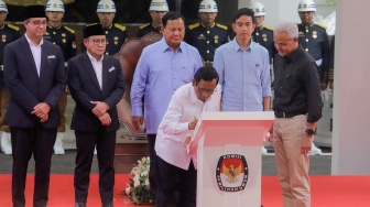 Pasangan Capres dan Cawapres Nomor Urut 3 Ganjar Pranowo (kanan) dan Mahfud MD (kiri) saat menandatangani Deklarasi Kampanye Pemilu Damai 2024 di KPU, Jakarta, Senin (27/11/2024). [Suara.com/Alfian Winanto]