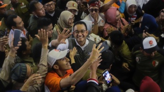 Calon Presiden (Capres) Nomor Urut 1 Anies Baswedan (tengah) menyapa pendukungnya saat menggelar kampanye perdana di GOR Ciracas, Jakarta, Selasa (28/11/2023). [Suara.com/Alfian Winanto]