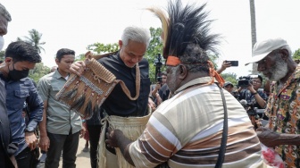 Calon presiden RI nomor urut 3, Ganjar Pranowo, dipasangkan celana khas Papua saat kampanye hari pertama di salah satu desa di Merauke, Papua, Selasa (28/11/2023). [Foto: Tim Media Ganjar-Mahfud]