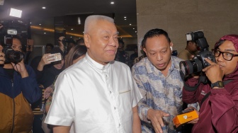 Ketua Harian Pengurus Besar Persatuan Bulutangkis Seluruh Indonesia (PBSI) sekaligus pemilik Hotel Alexis, Tirta Juana Darmadji atau Alex Tirta (tengah) usai menjalani pemeriksaan sebagai saksi di Bareskrim Polri, Jakarta Selatan, Jumat (1/12/2023). [Suara.com/Alfian Winanto]