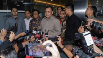 Ketua KPK non-aktif Firli Bahuri (tengah) memberikan keterangan usai menjalani pemeriksaan sebagai tersangka dalam kasus dugaan pemerasan terhadap mantan Menteri Pertanian Syahrul Yasin Limpo di Bareskrim Polri, Jakarta,  Jumat (1/12/2023). [Suara.com/Alfian Winanto]