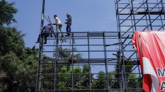 Pekerja menyelesaikan pembuatan kerangka papan reklame di Jakarta, Kamis (7/12/2023). [Suara.com/Alfian Winanto]