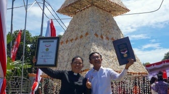 Ketua PHMJ GKI Bethel Doom Pendeta Jean Anthoni (kiri) dan Direktur operasional MURI Yusup Nadir (kanan) berfoto dengan latar pohon Natal dari kulit kerang di halaman GKI Bethel, Kepulauan Doom, Kota Sorong, Papua Barat Daya, Rabu (13/12/2023). [ANTARA FOTO/Olha Mulalinda/rwa]