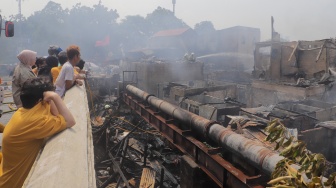 Warga melihat kebakaran di pemukiman padat di kawasan Manggarai, Tebet, Jakarta, Kamis (14/12/2023). [Suara.com/Alfian Winanto]