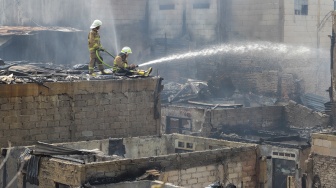 Petugas pemadam kebakaran memadamkan api yang membakar pekukiman padat di kawasan Manggarai, Tebet, Jakarta, Kamis (14/12/2023). [Suara.com/Alfian Winanto]