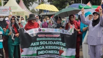 Medical Emergency Rescue Committee (MER-C) bersama Ikatan Dokter Indonesia (IDI), dan organisasi profesi kesehatan melakukan aksi di Patung Kuda, Jakarta, Jumat (15/12/2023). [Suara.com/Alfian Winanto]