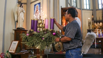 Petugas menyiapkan dekorasi dan membersihkan area Gereja Katedral, Jakarta, Kamis (21/12/2023). [Suara.com/Alfian Winanto]