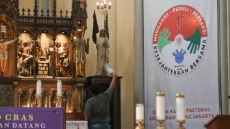 Petugas menyiapkan dekorasi dan membersihkan area Gereja Katedral, Jakarta, Kamis (21/12/2023). [Suara.com/Alfian Winanto]