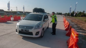 Anggota Satlantas Polres Boyolali mengarahkan pengemudi saat melintasi jalur fungsional tol Solo-Yogyakarta di Gerbang Tol Banyudono, Boyolali, Jawa Tengah, Jumat (22/12/2023). [ANTARA FOTO/Aloysius Jarot Nugroho/nym]