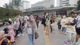 Warga berwisata di Kawasan Bundaran HI, Jakarta, Senin (25/12/2023). [Suara.com/Alfian Winanto]