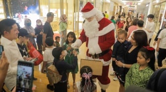 Sinterklas memberikan hadiah kepada pengunjung di salah satu Pusat Perbelanjaan di Jakarta, Senin (25/12/2023). [Suara.com/Alfian Winanto]