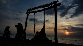 Sejumlah pengunjung menikmati suasana matahari terbenam (sunset) akhir tahun 2023 di kawasan pantai, Senggigi, Lombok Barat, NTB, Minggu (31/12/2023). [ANTARA FOTO/Ahmad Subaidi/rwa]