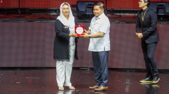 Politisi sekaligus Putri Presiden ke-4 Abdurrahman Wahid atau Gus Dur Yenny Wahid menerima penghargaan dalam Konser Lilin Putih di Balai Sarbini, Semanggi, Jakarta, Rabu (3/1/2024). [Suara.com/Alfian Winanto]