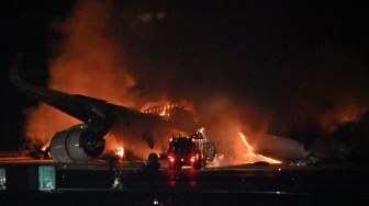 Penampakan pesawat Japan Airlines terbakar di landasan Bandara Haneda, Tokyo, Jepang, Selasa (2/1/2024). [Richard A. BROOKS / AFP]