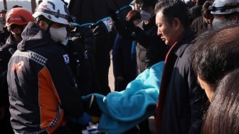 Petugas medis membawa pemimpin partai oposisi Korea Selatan Lee Jae-myung dengan tandu setelah diserang saat konferensi pers di Busan, Korea Selatan, Selasa (2/1/2024). [YONHAP / AFP]