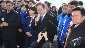 Pemimpin partai oposisi Korea Selatan Lee Jae-myung (tengah) berbicara kepada wartawan saat konferensi pers di Bandara Baru Busan, Korea Selatan, Selasa (2/1/2024). [YONHAP / AFP]