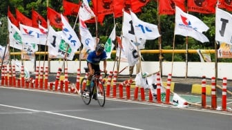 Warga melintas di samping alat peraga kampanye (APK) pemilu 2024 yang terpasang di pembatas jalur sepeda (stick cone) di kawasan Menteng, Jakarta, Selasa (9/1/2024). [Suara.com/Alfian Winanto]