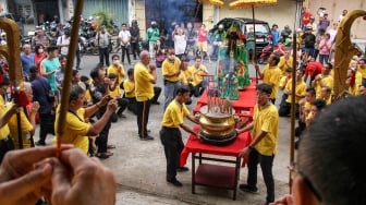 Warga melihat prosesi pemindahan patung Dewa Kwan Kong ke gedung baru klenteng di Makassar, Sulawesi Selatan, Rabu (10/1/2024).  [ANTARA FOTO/Arnas Padda/aww]