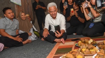 Calon presiden nomor urut 3 Ganjar Pranowo (tengah) berbincang dengan anak pemilik rumah Waidah (kedua kiri), Fikri melalui panggilan video saat menginap di rumah warga di Tegal, Jawa Tengah, Rabu (10/1/2024). [ANTARA FOTO/Akbar Nugroho Gumay/nym]