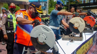 Kepala Dinas Perhubungan Abdul Kadir (kedua kiri) didampingi perwira TNI memotong knalpot brong saat pemusnahan knalpot brong di Polres Tegal Kota, Jawa Tengah, Kamis (11/1/2024). [ANTARA FOTO/Oky Lukmansyah/nz]