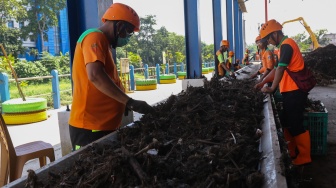 Petugas memilah sampah dari mesin pencacah di tempat penyaringan sampah di TB Simatupang, Jakarta, Jumat (12/1/2024). [Suara.com/Alfian Winanto]