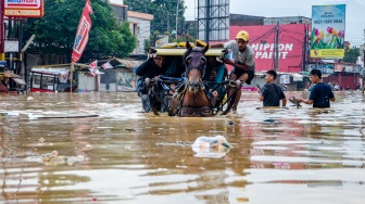 Warga menaiki delman melewati genangan banjir di Dayeuhkolot, Kabupaten Bandung, Jawa Barat, Jumat (12/1/2024). [ANTARA FOTO/Novrian Arbi/tom]