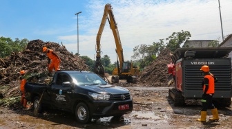 Ekskavator mengangkut sampah dari Kali Ciliwung ke mesin pencacah di tempat penyaringan sampah di TB Simatupang, Jakarta, Jumat (12/1/2024). [Suara.com/Alfian Winanto]