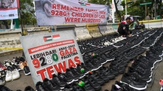 Seorang pengunjuk rasa meletakkan sepatu yang menyimbolkan tewasnya ribuan anak di Gaza saat aksi bela Palestina di depan Kedubes Amerika Serikat, Jakarta, Senin (15/1/2024). [ANTARA FOTO/Akbar Nugroho Gumay/rwa]