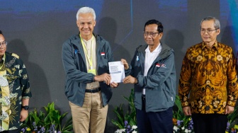 Pasangan Capres dan Cawapres nomor urut tiga, Ganjar Pranowo (kiri) dan Mahfud MD (kanan) menunjukan pakta integritas saat acara PAKU Integritas di Gedung Merah Putih KPK, Jakarta, Rabu (17/1/2024). [Suara.com/Alfian Winanto] 