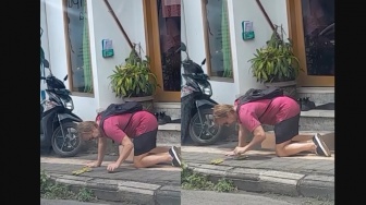 Bikin Salut, Bule Ini Rela Nungging Demi Rapikan Bunga Canang di Jalan