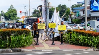 Aktivis dari Koalisi Pejalan Kaki menggelar aksi di Halte Tugu Tani, Jakarta, Senin (22/1/2024). [Suara.com/Alfian Winanto]